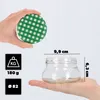 A hand holds a green and white checkered lid over a clear glass jar, with dimensions and weight indicated. Anteprima dell’immagine prodotto