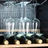 A close-up shot of wine bottles and hanging wine glasses in what appears to be a wine cooler or cellar. Produktbild-Vorschau