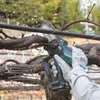 A person wearing gloves is using a cordless pruning saw to cut a branch. Produktbild-Vorschau
