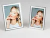 Two silver and white photo frames are displayed on a white surface against a light gray background. Produktbild-Vorschau