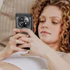 A woman is lying down and looking at her phone, which is in a black protective case. Náhled obrázku produktu