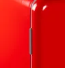 Close-up of a red refrigerator with a gray handle. Voir les images du produit