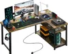 A corner gaming desk setup with multiple monitors, a computer, gaming consoles, and accessories. Náhľad obrázku produktu