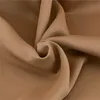 A close-up, studio shot of draped camel-colored fabric. Náhled obrázku produktu