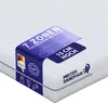 A close-up, angled view of a white mattress with a blue label wrapped around it, highlighting product features. Produktbild-Vorschau