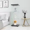 A glass display cabinet with items on shelves, placed next to a bed in a bedroom. Produktbild-Vorschau