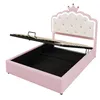A pink bed frame with the mattress support lifted to reveal storage space underneath. The headboard is white and tufted with a pink crown detail at the top. Podgląd zdjęcia produktu
