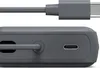 Close-up view of the side of a dark gray power bank, showing a USB-C port and a cable connected to another USB-C port. Anteprima dell’immagine prodotto