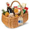 A wicker gift basket filled with holiday items, including a bottle of wine, dried oranges, small jars, and gift-wrapped boxes. Produktbild-Vorschau