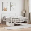 A white metal bed frame with bedding in a bedroom setting. Náhled obrázku produktu
