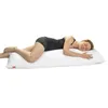 A woman is lying on her side on a long white pillow, with her head resting on it and her legs bent. Náhled obrázku produktu