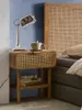 A bedside table with a lamp and a cup of tea next to a bed. Produktbild-Vorschau