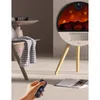 A modern electric fireplace heater with a circular display and wooden legs, placed in a living room setting. Produktbild-Vorschau