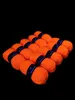 A collection of orange yarn balls arranged in rows on a black background. Produktbild-Vorschau