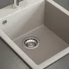 A close-up view of a beige sink with a chrome drain. Náhled obrázku produktu