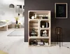A room with a wooden crate shelf unit filled with books and decorative items, next to a floor lamp and a framed picture on the wall. A bed and a small side table are visible in the background. Produktbild-Vorschau