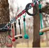 A close-up view of a ninja line with various attachments hanging from it, set against a blurred outdoor background of trees. Produktbild-Vorschau