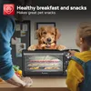 A golden retriever dog is peeking over a dehydrator with a bone in its mouth, while a child and an adult look on. Produktbild-Vorschau