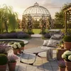 A tranquil garden scene with a lounge chair, gazebo, and various plants. Produktbild-Vorschau