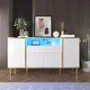 A modern white sideboard with gold trim and LED lighting, decorated with a vase of flowers, a framed abstract art piece, and decorative objects. Produktbild-Vorschau