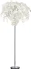 A white floor lamp with a chrome stem and base, resembling a tree with white leaves. Produktbild-Vorschau