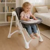 A young girl is sitting in a high chair and drawing. Voir les images du produit