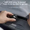 A hand is holding a small black device with a white accent, about to insert it into a zipper pocket on a gray bag. Produktbild-Vorschau