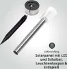 Components of a solar garden stake are laid out against a light gray background, with text describing the delivery contents. Produktbild-Vorschau