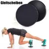 Zwei schwarze Gleitscheiben, eine mit strukturierter Oberseite, neben einer Frau, die sie für eine Übung verwendet Podgląd zdjęcia produktu