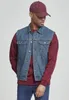 A man wearing a denim vest over a burgundy sweatshirt and jeans. Produktbild-Vorschau