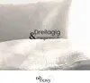 A close-up of a textured fabric, likely bedding, with text overlay and a logo at the bottom. Produktbild-Vorschau