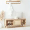 A wooden shoe bench with storage and a cushioned seat, placed against a white wall with a coat rack above. Produktbild-Vorschau