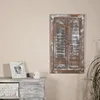 A rustic wooden wall mirror with shutter-like doors, placed above a distressed wooden dresser with a woven basket. Produktbild-Vorschau