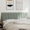 A bed with a headboard and bedding in a room. Produktbild-Vorschau