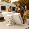People enjoying an outdoor gathering with a caravan in the background, with a satellite dish in the foreground. Produktbild-Vorschau