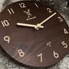 A close-up shot of a wooden wall clock with a deer logo and the text 'Holzwerk'. Voir les images du produit