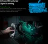 A hand holding a 3D scanner pointed at a green engine block, with a blue 3D model of an engine in the upper right corner. Náhled obrázku produktu