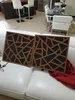 Two acoustic wall panels with a geometric pattern are placed on a white sofa in a living room setting. Podgląd zdjęcia produktu