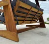 Close-up view of the underside and side of a wooden swing chair with dark gray cushions. Podgląd zdjęcia produktu