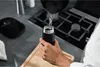 A person is pouring hot water into a black thermos. Podgląd zdjęcia produktu