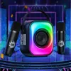 A portable karaoke machine with two microphones and LED lights, set against a vibrant, stage-like background with neon lights and confetti. Podgląd zdjęcia produktu