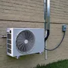 An outdoor air conditioning unit mounted on a brick wall. Podgląd zdjęcia produktu