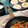 A cooking scene with a frying pan containing chopped vegetables and a griddle pan with pancakes being cooked, along with a pitcher of milk. Náhľad obrázku produktu