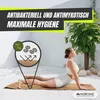 A woman is doing yoga on a mat outdoors, with a diagram illustrating the mat's properties. Anteprima dell’immagine prodotto