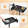 A salon trolley with hair styling tools on top, and a hand cleaning the tray below. Voir les images du produit