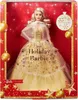 A Barbie doll in a gold dress, inside its packaging, with holiday-themed decorations. Náhled obrázku produktu