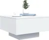 A white coffee table with a plant, a cup of coffee, and books on top. Produktbild-Vorschau