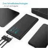 A black power bank is shown with an iPad and two smartphones, along with charging cables, suggesting its use for charging multiple devices. Produktbild-Vorschau