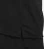 A close-up view of the bottom hem of a black t-shirt, showing a side slit. Podgląd zdjęcia produktu