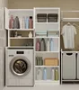 A laundry room with a washing machine, shelves filled with cleaning supplies, towels, and laundry baskets. Produktbild-Vorschau